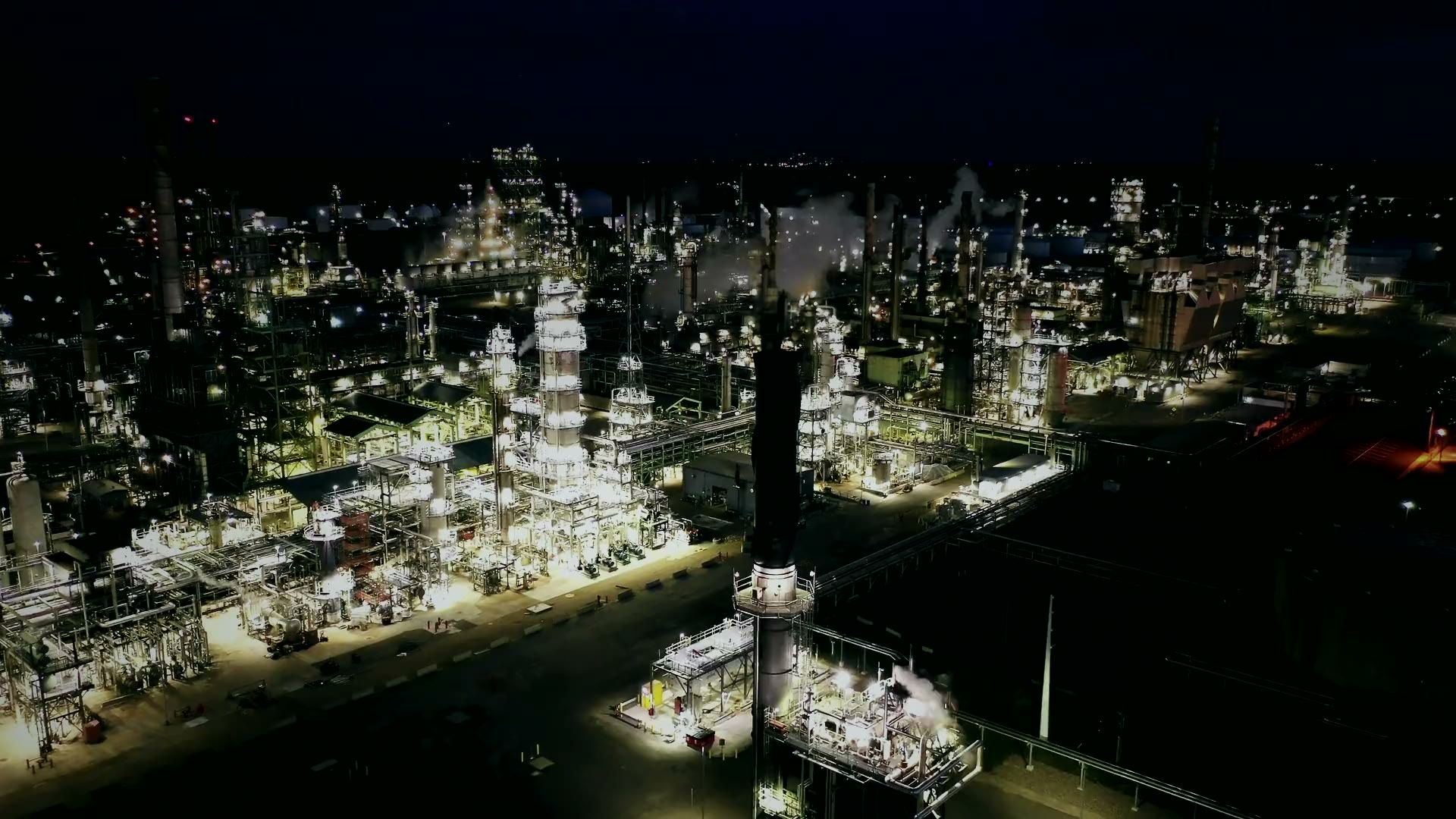 A refinery lit up at night, seen from the air